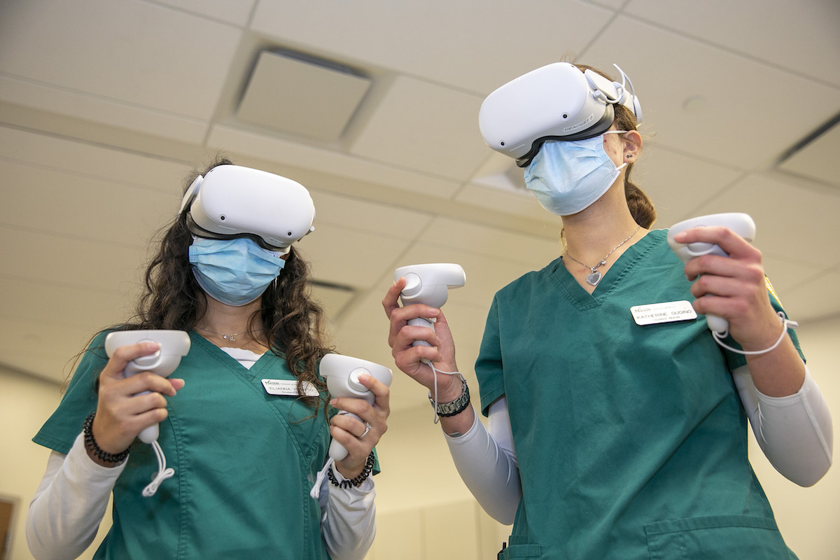 two women wearing nursing uniforms and virtual reality gear